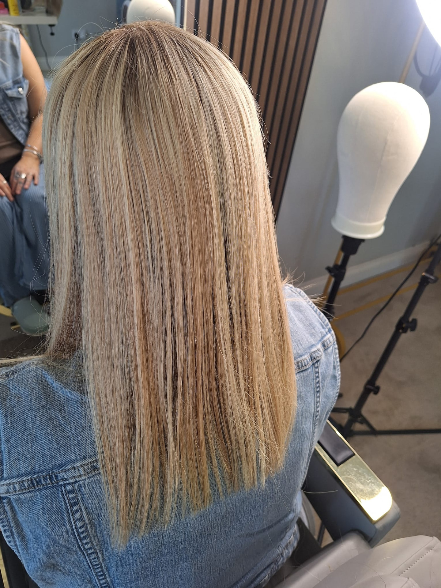 A client's own hair blended with a human hair topper, seen from behind in the studio